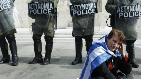 Una manifestante se lamenta en Atenas frente al Parlamento
